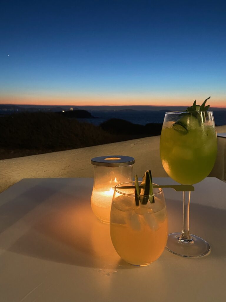 Two beverages on a table with a sunset