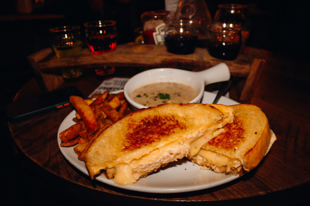 A crab grilled cheese with fries and clam chowder.