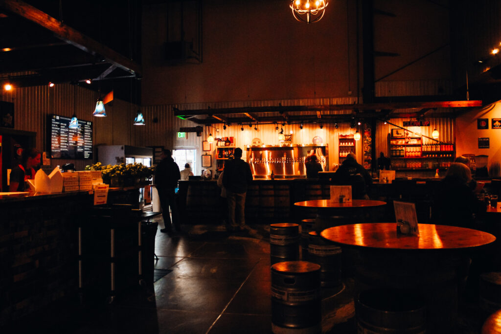 Interior of a dark brewery with warm lighting.