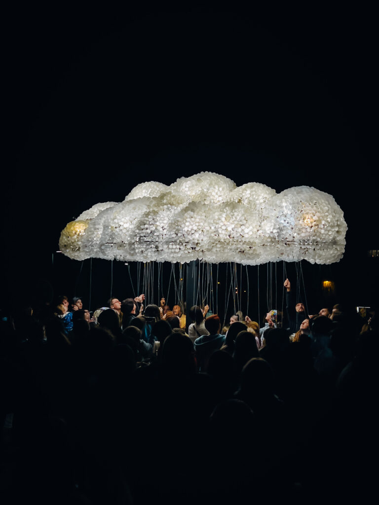 People holding stings under a cloud of lights.