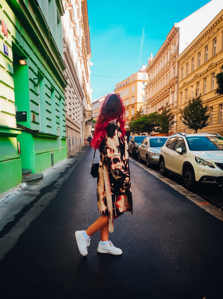 A woman in a coat on the streets of Prague.