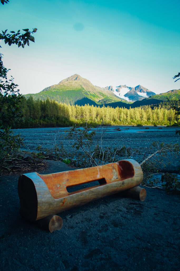 A wooden bench with a mountain in the background