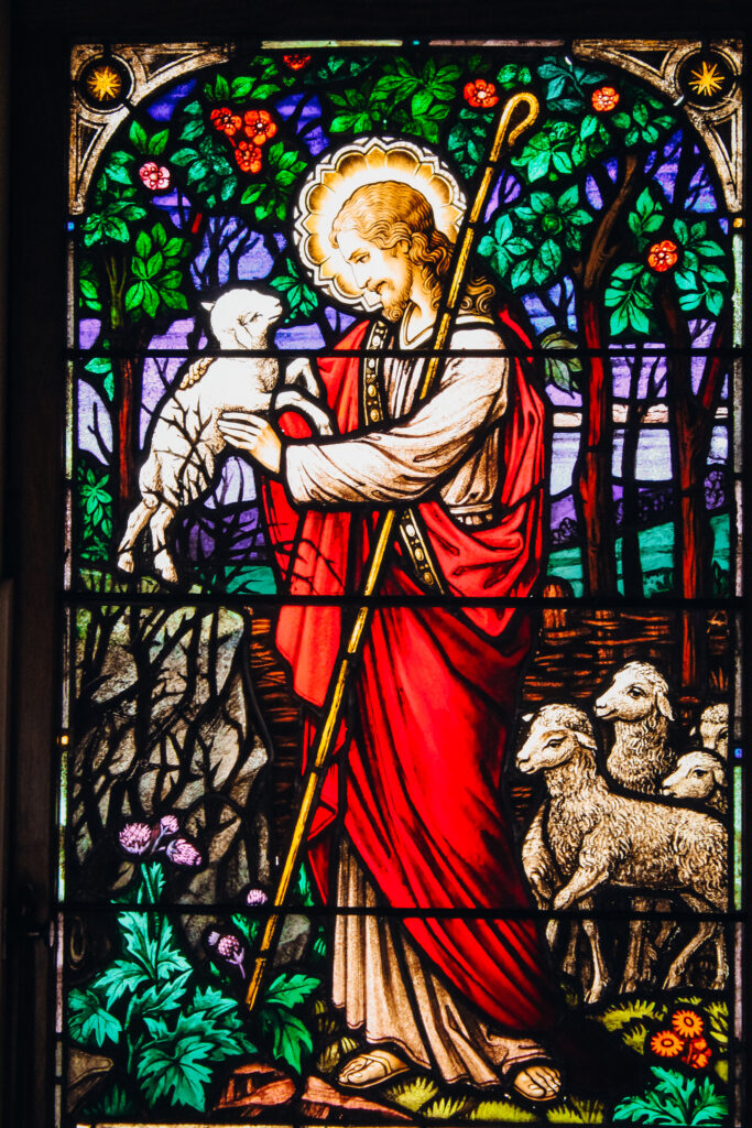 Stained glass of Christ holding a sheep.