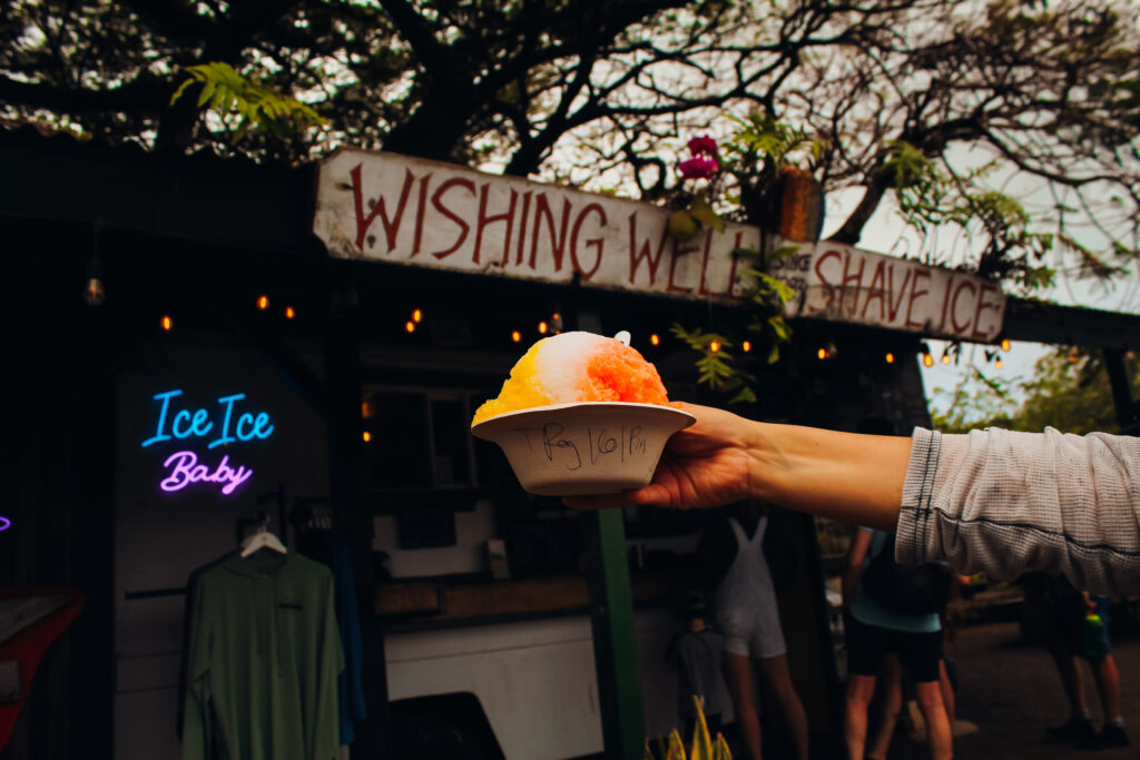 Shaved Ice held in front of a stand.