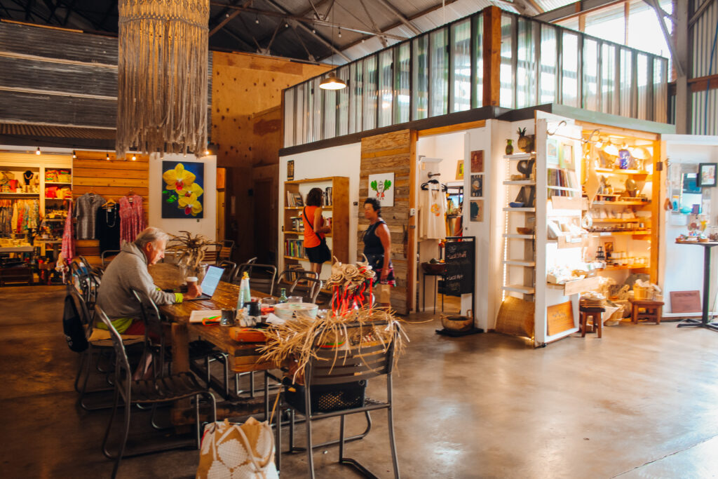 A marketplace with stalls in a warehouse.