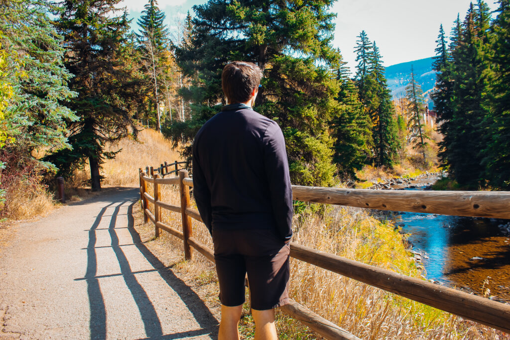 A man standing looking out at the path.