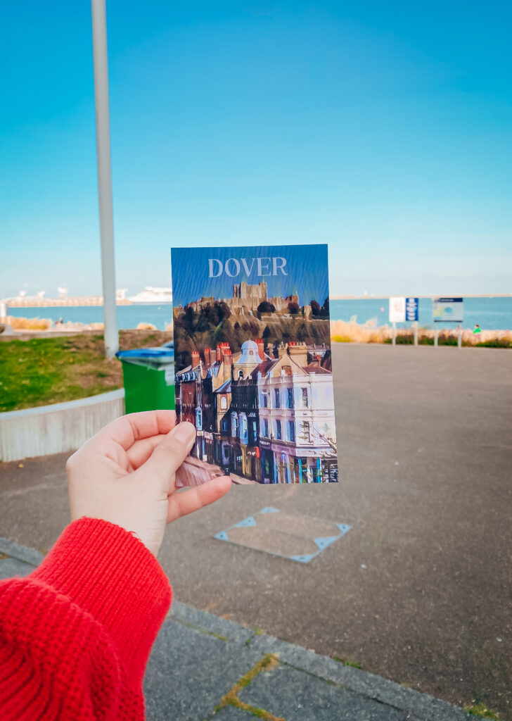 Hand holding a postcard of Dover